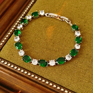 Bracelet argenté exquis avec pierres vertes sur un coffret en velours vert