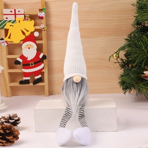 Close-up of a Christmas gnome with a white knit hat, grey beard, and long striped legs