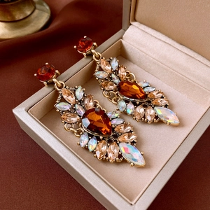 Detail view of vintage amber teardrop earrings with crystals in a velvet jewelry box