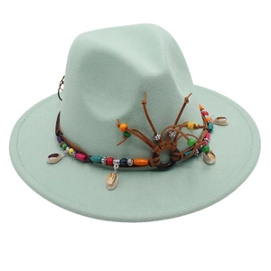 Detail of mint green fedora hat featuring ethnic beads and natural cowrie shells