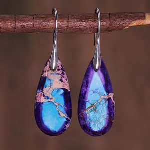 Macro view of teardrop imperial stone earrings with purple and blue natural textures