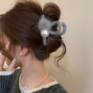 Grey faux fur hair claw clip with large pearl on model wearing a grey sweater