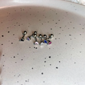 Close-up of heart-shaped zircon earrings in six colors with screw-back metal posts