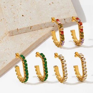 Boucles d'oreilles dorées en C avec zircons colorés sur des supports en pierre