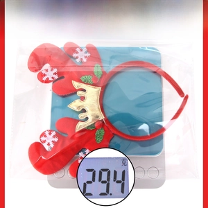Detailed view of red Christmas reindeer antler headband with crown on a digital scale