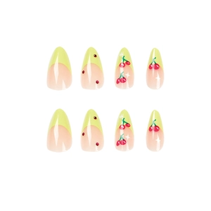 French tip press-on nails with green edges, cherry patterns, and red rhinestones