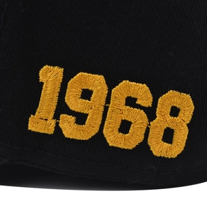 Close-up of premium 1968 yellow 3D embroidery on black twill cotton baseball cap