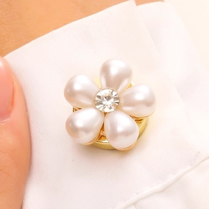 Gros plan d'un clip de chemise fleurie à cinq perles avec un zircon central brillant