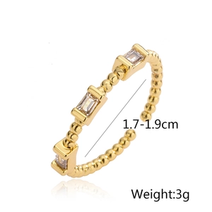 Detail view of gold geometric open ring with cubic zirconia and beaded band design
