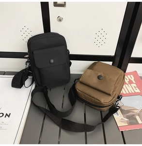 Detail view of black and brown nylon crossbody bags with adjustable straps and snap closure