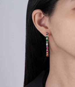 Close-up of elegant gold long drop earrings featuring multicolor faceted gemstones
