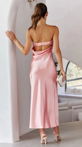 Dettaglio dell'abito in raso rosa con elegante design senza schienale e tessuto lucido