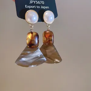Vintage-style drop earrings with pearl, amber resin, and marbled fan charms on display card
