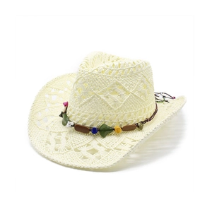 Detail of cream straw cowboy hat featuring hollow diamond patterns and colorful bead band