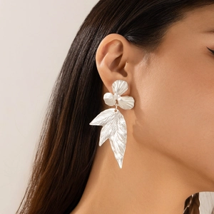 Detailed view of silver ginkgo leaf flower earrings with pearl tassels on model