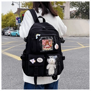 Close-up of black Ita-bag with transparent PVC window showing plush bear and decor pins