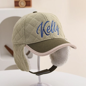 Detail der gesteppten Wintermütze in Olivgrün mit Lammfellfutter und Kelly-Stickerei