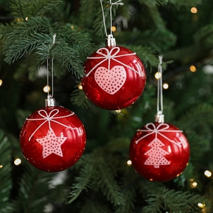 Red Christmas ornaments set with star and heart patterns on festive pine background