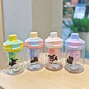 Detailed view of four colorful cartoon cat plastic water bottles with straws on a wooden table