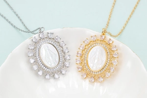 Detailed close-up of Virgin Mary medallion pendants with natural zircon and mother of pearl