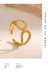 Macro detail of a golden twisted rope open ring with a hammer texture on a stone background