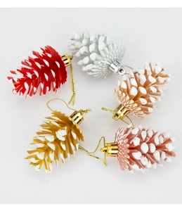Détail de suspensions de pommes de pin de 6 cm aux couleurs variées avec pointes effet neige
