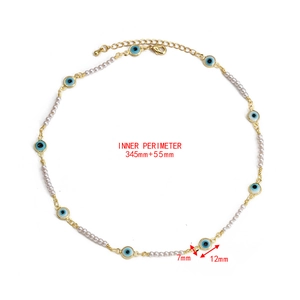 Detail of beaded evil eye necklace featuring white pearls and a gold lobster clasp