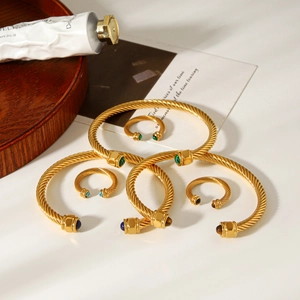 Detailed view of gold twisted cable open bangles and rings with natural stone beads
