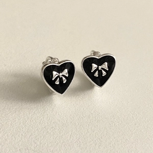 925 silver heart hoop earrings with black enamel and a silver bow detail in a top view