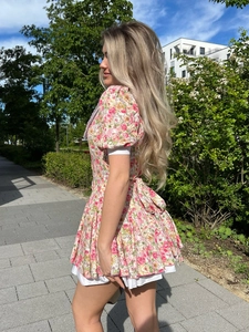 Floral mini dress with puff sleeves and rose print seen from a side back view