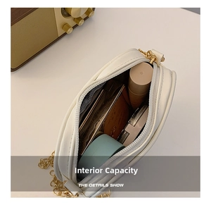 Detail showing the inner capacity of the white heart crossbody bag with golden chain
