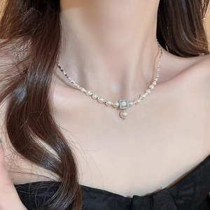 Detailed view of gold plated necklace with blue opal pendant and freshwater pearls