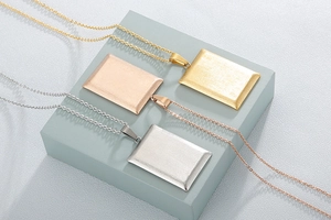 Detailed view of rectangular pendants in gold, silver, and rose gold finishes on O-chains