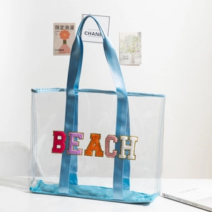 Detail of colorful chenille BEACH embroidery on a large transparent PVC tote bag