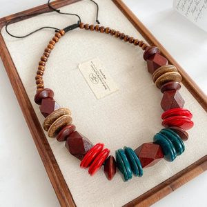 Detailed shot of ethnic wooden beaded necklace with colorful spacers on linen tray