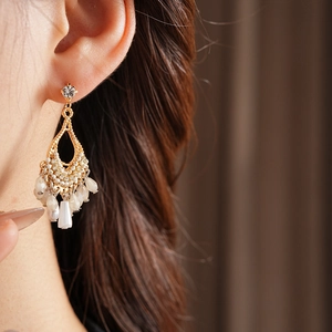 Detail of vintage bohemian teardrop earrings with crystals and pearl bead tassels