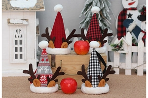 Dettaglio di mini sacchetti regalo di Natale in maglia con corna di renna e motivi festivi