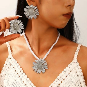 Macro detail of bohemian silver daisy necklace and earrings set on a model