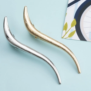 Minimalist S-shaped metal hair clips in gold and silver with a brushed texture finish