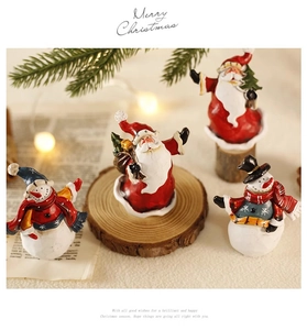 Miniatur-Weihnachtsmann- und Schneemannfiguren auf Holzsockel mit festlichen Lichtern