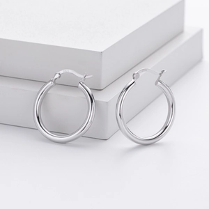 Detailed close-up of S925 sterling silver stamp on minimalist polished hoop earrings