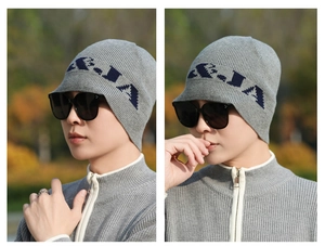 Detail of grey knitted hat with blue letter jacquard, visor and ear protection design