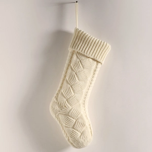 Detailed view of the thick cable knit texture on a creamy white Christmas stocking decor
