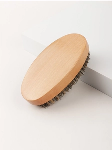 Detail of oval wooden beard brush with natural boar bristles on minimalist background