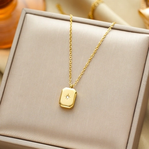 Gold titanium steel starburst pendant necklace with cubic zirconia on velvet