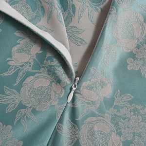 Macro shot of elegant teal floral jacquard fabric with a sleek metal zipper detail