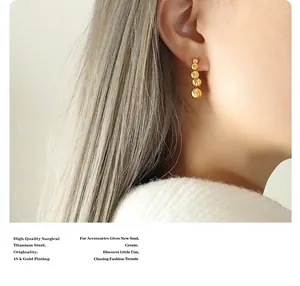 Macro shot of 18k gold plated surgical titanium steel graduated sphere drop earrings