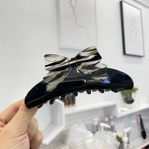 French vintage black acetate claw clip with a stylish black and white striped bow