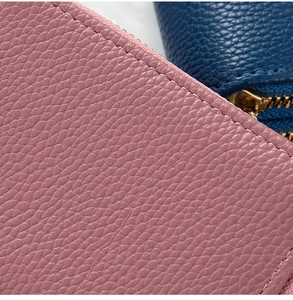 Detalle de la cartera de cuero granulado con costuras limpias y cremallera de metal dorado
