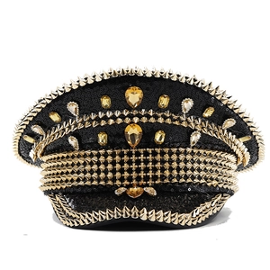 Macro detail of punk captain hat with golden spikes, black sequins and amber gems